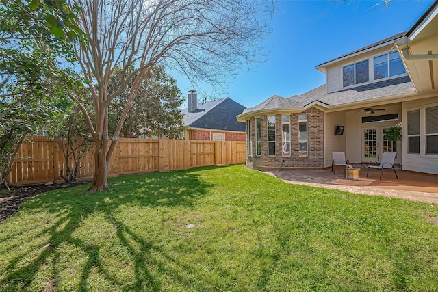 view of yard with ceiling fan, french doors, a patio area, and a fenced backyard