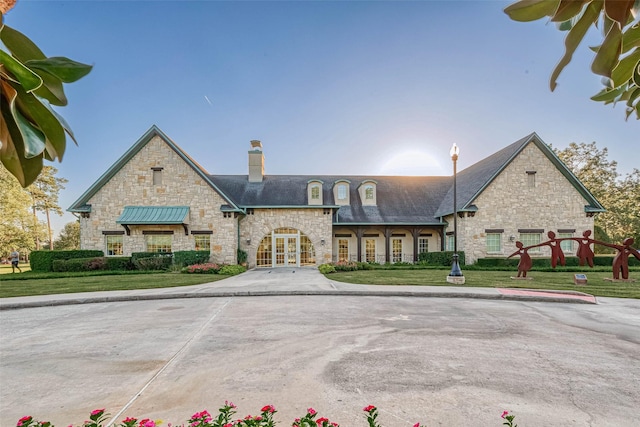 view of front of property featuring french doors, a chimney, and a front yard