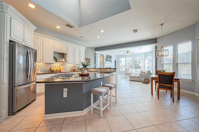 kitchen featuring a breakfast bar area, light tile patterned flooring, stainless steel appliances, a sink, and visible vents