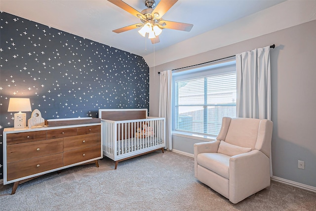 bedroom featuring carpet floors, wallpapered walls, baseboards, and a crib