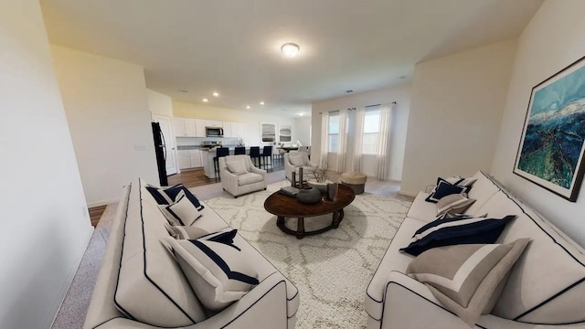 living area featuring baseboards, light wood-style flooring, and recessed lighting