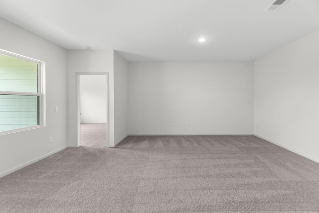 carpeted spare room featuring baseboards, visible vents, and recessed lighting