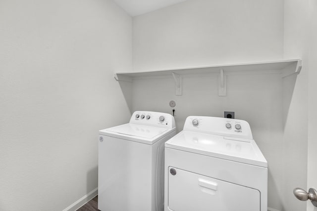 laundry area featuring laundry area, dark wood-type flooring, washer and clothes dryer, and baseboards