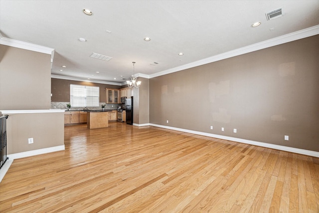 unfurnished living room with visible vents, baseboards, light wood-style flooring, ornamental molding, and a chandelier