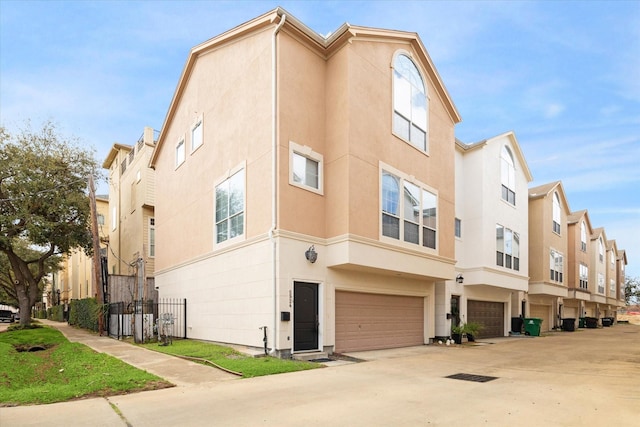 exterior space with driveway, an attached garage, and fence