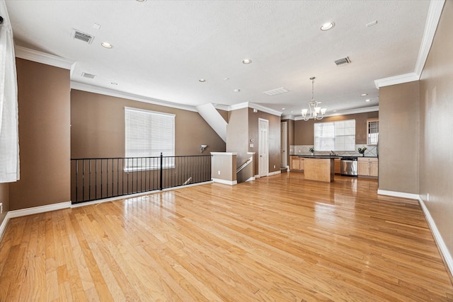 unfurnished living room with light wood-type flooring, visible vents, and a notable chandelier