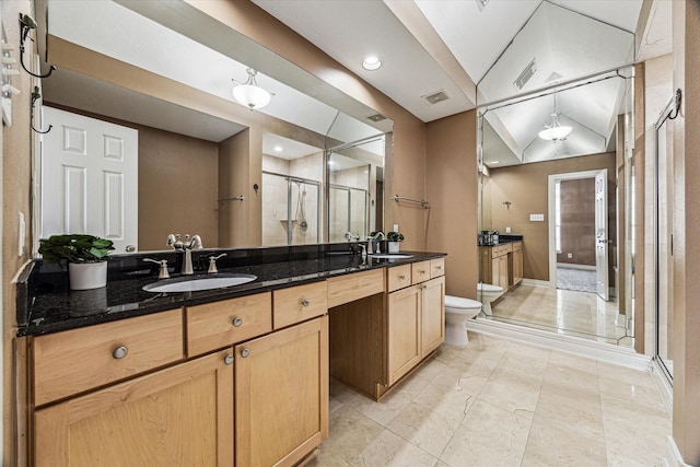 full bathroom with double vanity, a stall shower, visible vents, toilet, and a sink