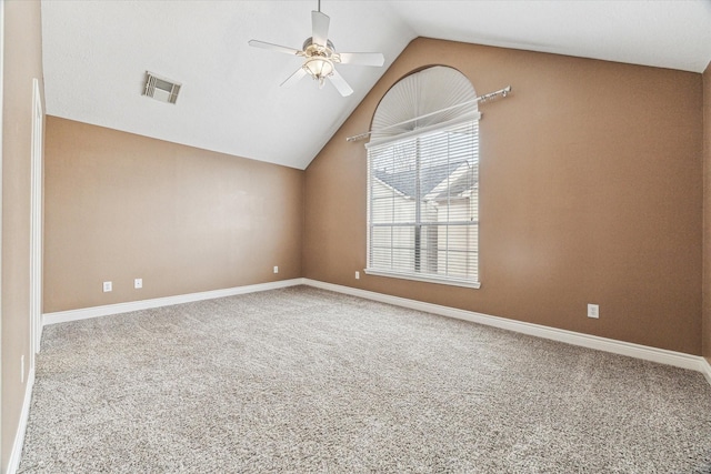 unfurnished room featuring a ceiling fan, carpet, visible vents, and vaulted ceiling