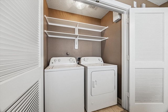 laundry area with laundry area, visible vents, a textured ceiling, and separate washer and dryer