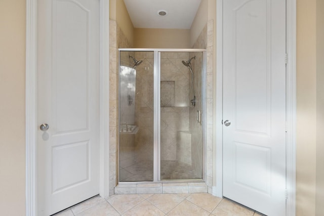 full bath with a shower stall and tile patterned floors