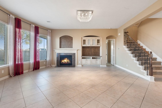 unfurnished living room with visible vents, stairway, baseboards, and light tile patterned flooring