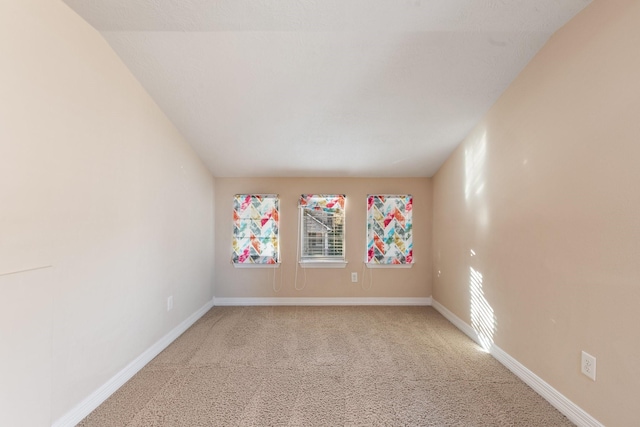 carpeted empty room featuring baseboards