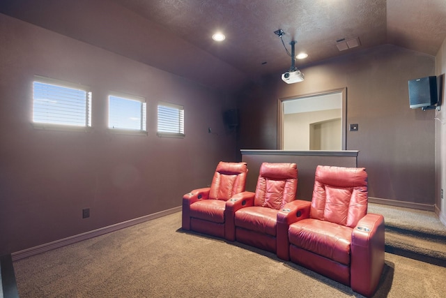 home theater room featuring carpet, baseboards, vaulted ceiling, and a textured ceiling