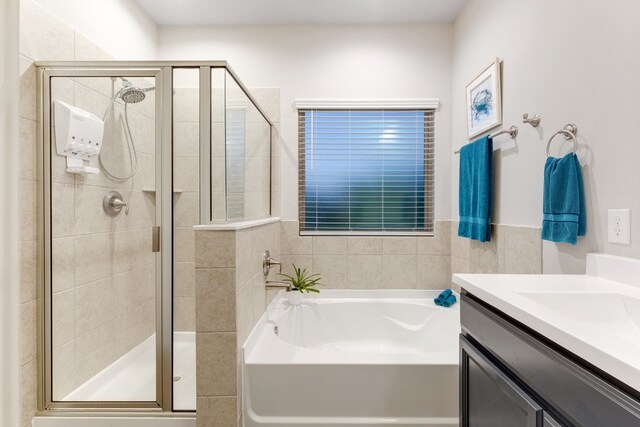 full bath with a shower stall, vanity, and a garden tub