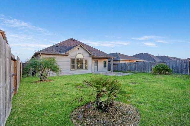 back of house with a patio, a yard, and a fenced backyard