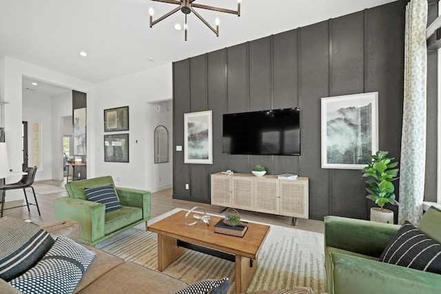 living room with light wood-style floors, recessed lighting, baseboards, and an inviting chandelier