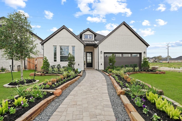 view of front of house featuring metal roof, a garage, brick siding, a standing seam roof, and a front yard