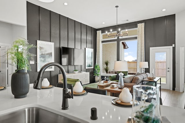 kitchen with dark cabinets, light countertops, decorative light fixtures, and an inviting chandelier