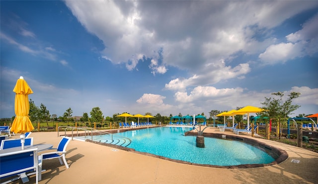 pool with a patio area and fence