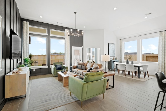 living area with recessed lighting, visible vents, a notable chandelier, and wood finished floors