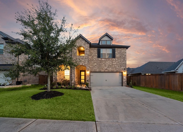 view of front facade featuring brick siding, fence, concrete driveway, a yard, and an attached garage