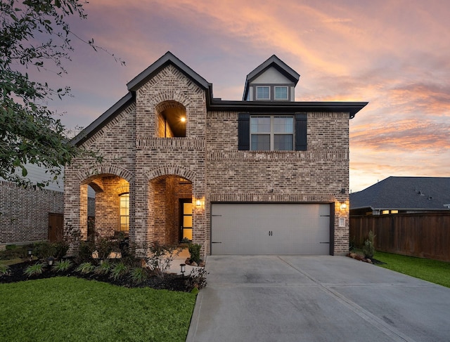 view of front facade featuring concrete driveway, a garage, fence, and brick siding