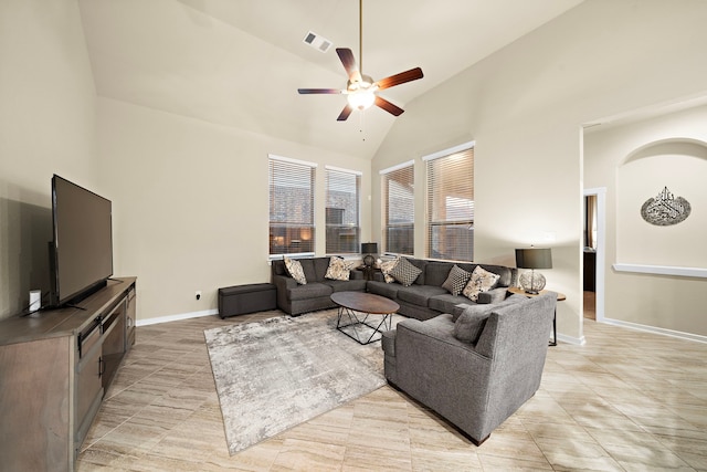 living room with baseboards, visible vents, high vaulted ceiling, light tile patterned flooring, and ceiling fan