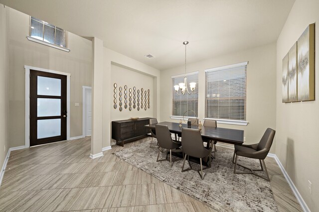 dining space with a chandelier, visible vents, and baseboards