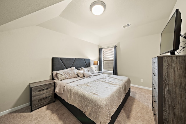 bedroom with visible vents, baseboards, light colored carpet, and vaulted ceiling