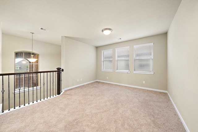 unfurnished room featuring carpet flooring, baseboards, and visible vents