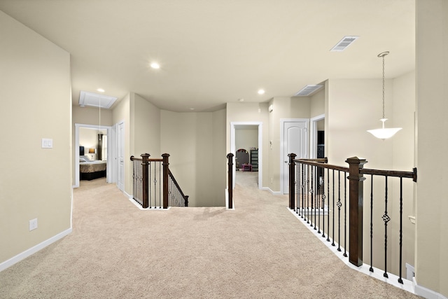 hallway with visible vents, carpet floors, attic access, recessed lighting, and an upstairs landing