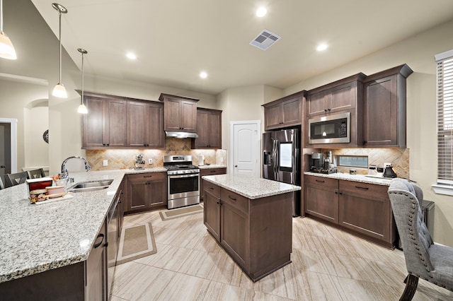 kitchen featuring visible vents, a sink, appliances with stainless steel finishes, a peninsula, and dark brown cabinets