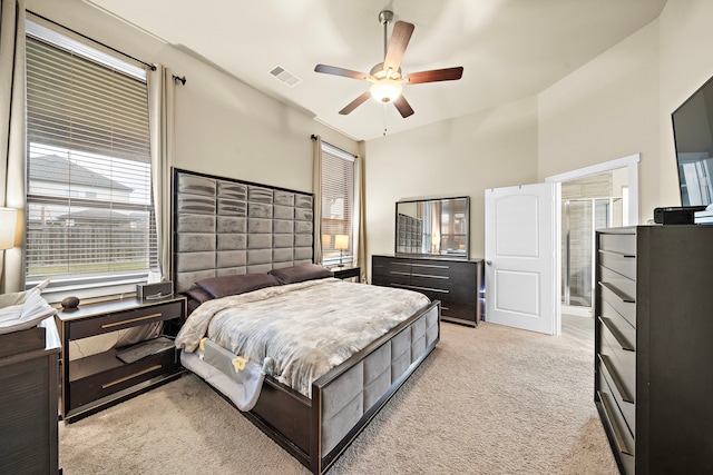 bedroom featuring visible vents, light colored carpet, and a ceiling fan