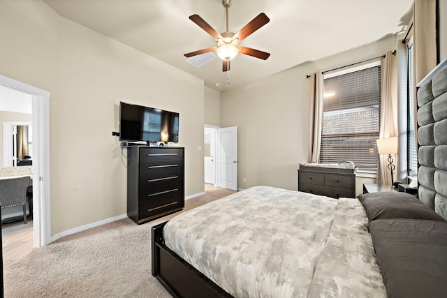 bedroom featuring light carpet, a ceiling fan, and baseboards