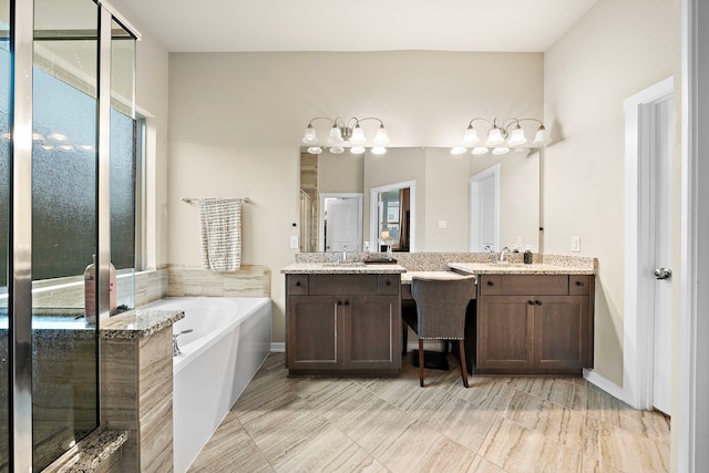 full bath with a shower stall, two vanities, a garden tub, and a sink