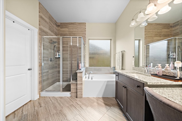 full bathroom with an inviting chandelier, a shower stall, a garden tub, and vanity