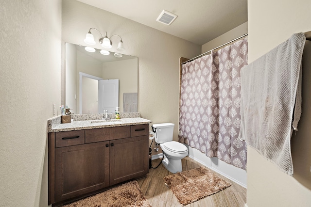 full bathroom with vanity, toilet, and visible vents