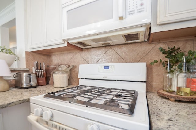 kitchen featuring white appliances, white cabinetry, and tasteful backsplash