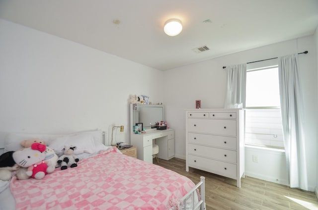 bedroom with light wood-type flooring and visible vents