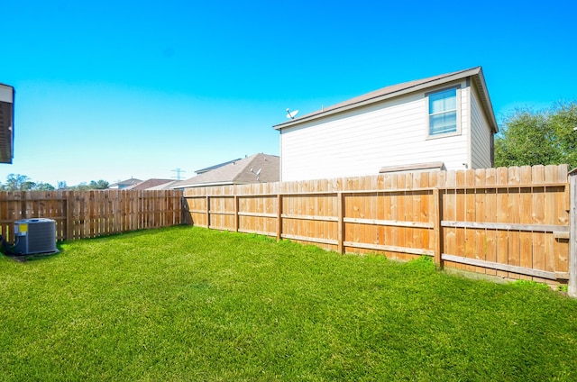 view of yard featuring central AC unit and fence