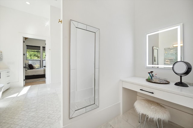 ensuite bathroom with tile patterned flooring, vanity, and ensuite bath