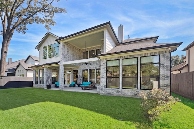 rear view of house featuring brick siding, a yard, a patio, an outdoor hangout area, and a fenced backyard