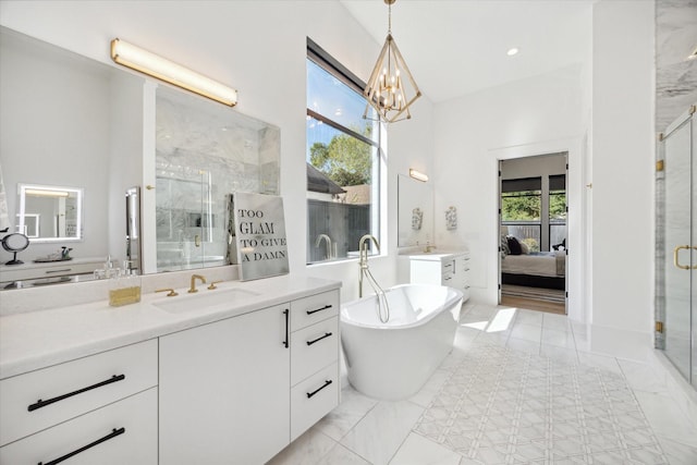 ensuite bathroom featuring a stall shower, marble finish floor, a sink, and ensuite bath