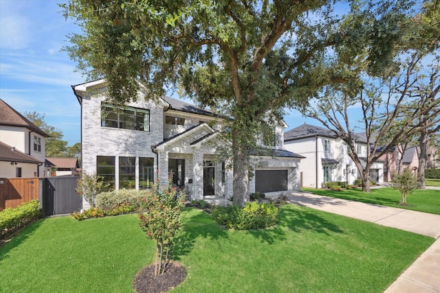 traditional-style home featuring concrete driveway, fence, and a front lawn