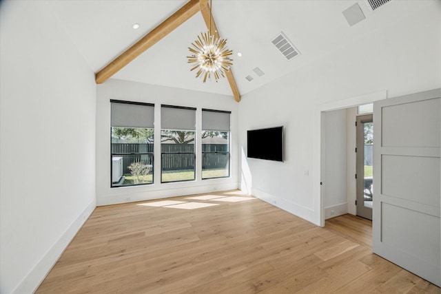 interior space with a chandelier, plenty of natural light, beam ceiling, and light wood-style floors