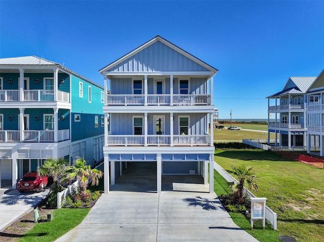 beach home with a carport, a front lawn, board and batten siding, and driveway