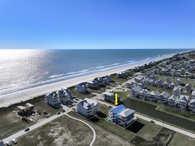 birds eye view of property featuring a view of the beach, a water view, and a residential view