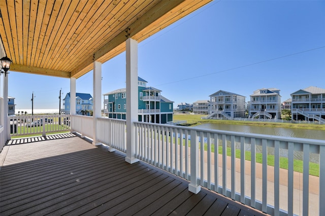 wooden deck featuring a water view and a residential view