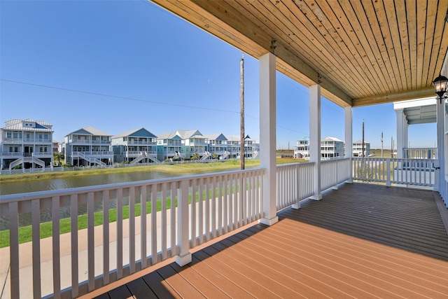 wooden terrace with a residential view and a water view