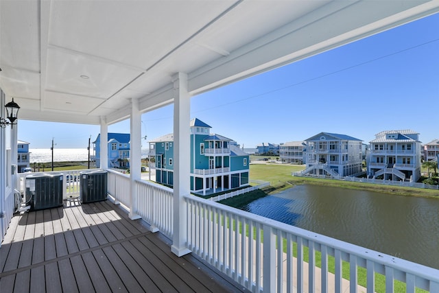 wooden terrace featuring a water view, a residential view, and central AC